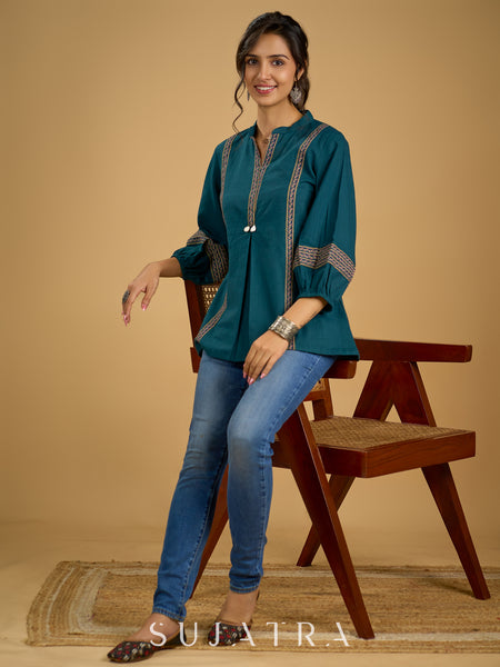 Elegant cotton teal top featuring graceful and unique detailing.