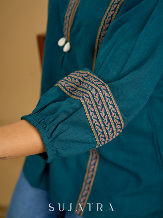 Elegant cotton teal top featuring graceful and unique detailing.