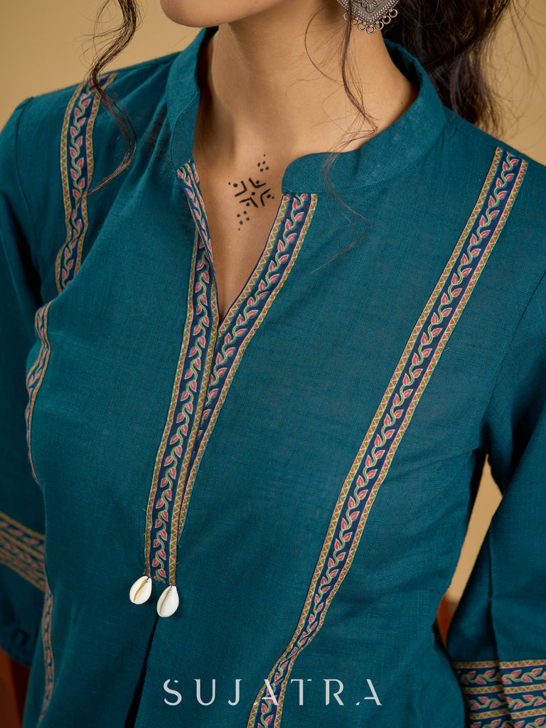 Elegant cotton teal top featuring graceful and unique detailing.