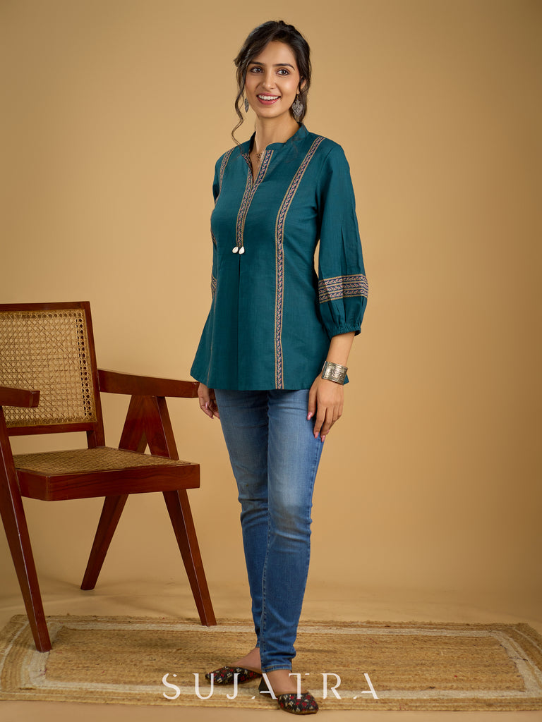 Elegant cotton teal top featuring graceful and unique detailing.