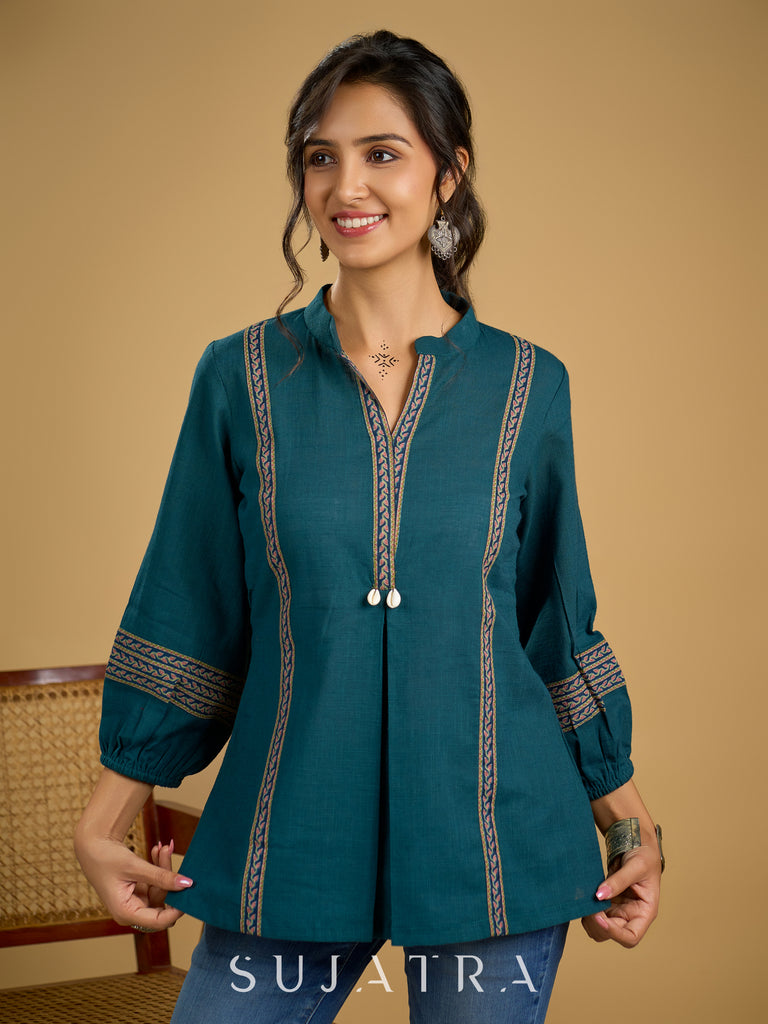 Elegant cotton teal top featuring graceful and unique detailing.
