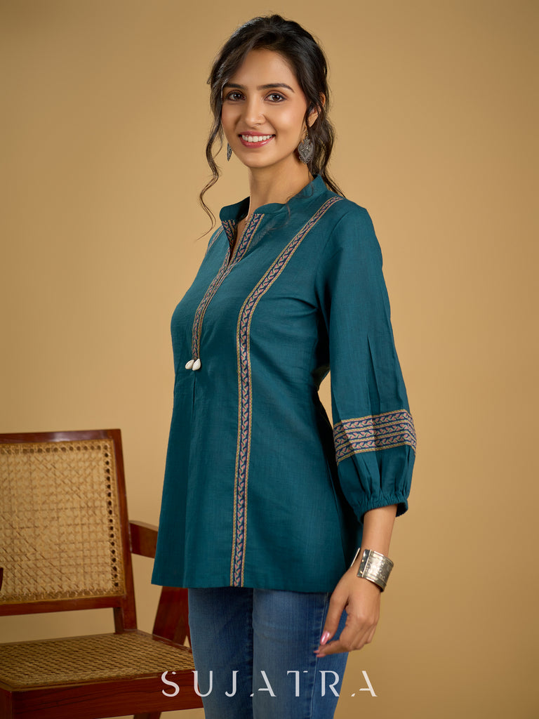Elegant cotton teal top featuring graceful and unique detailing.