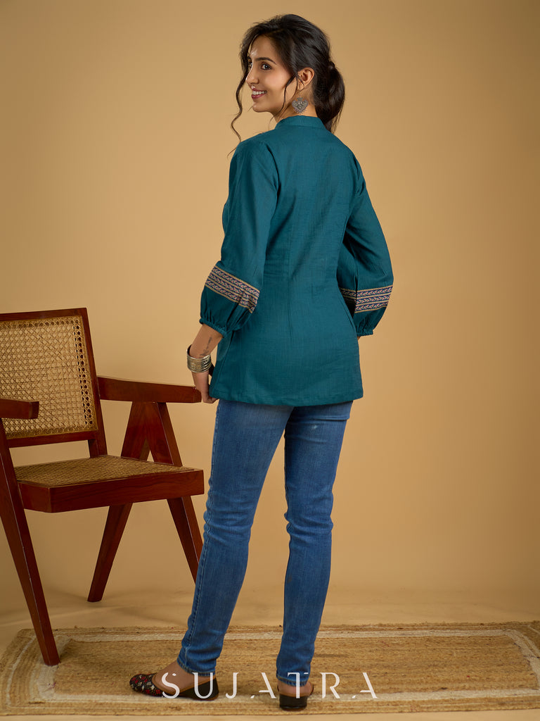 Elegant cotton teal top featuring graceful and unique detailing.