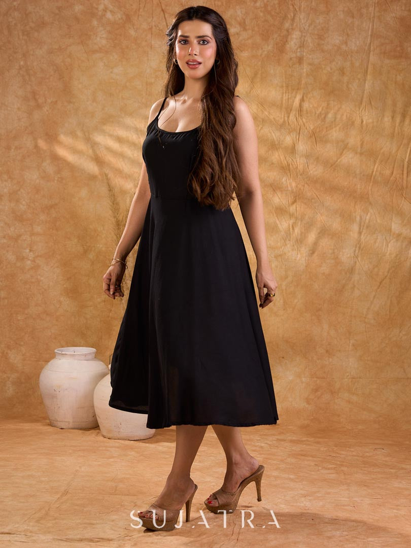 Fluid black rayon slip dress with a flattering bias silhouette, featuring a smooth fall, gentle movement, and a refined, understated appeal.