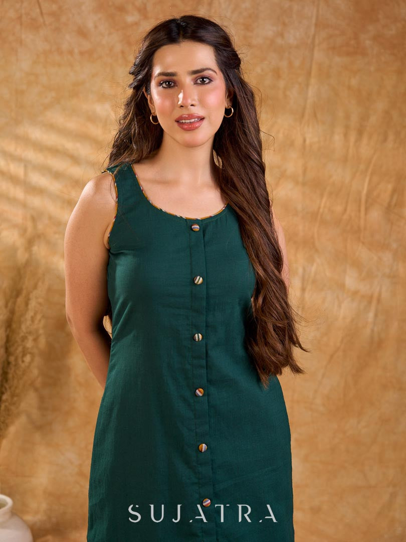 Rich bottle green cotton dress in a straight silhouette, detailed with mustard Ikat buttons and accents, creating a neat, balanced look with a polished, easygoing appeal.
