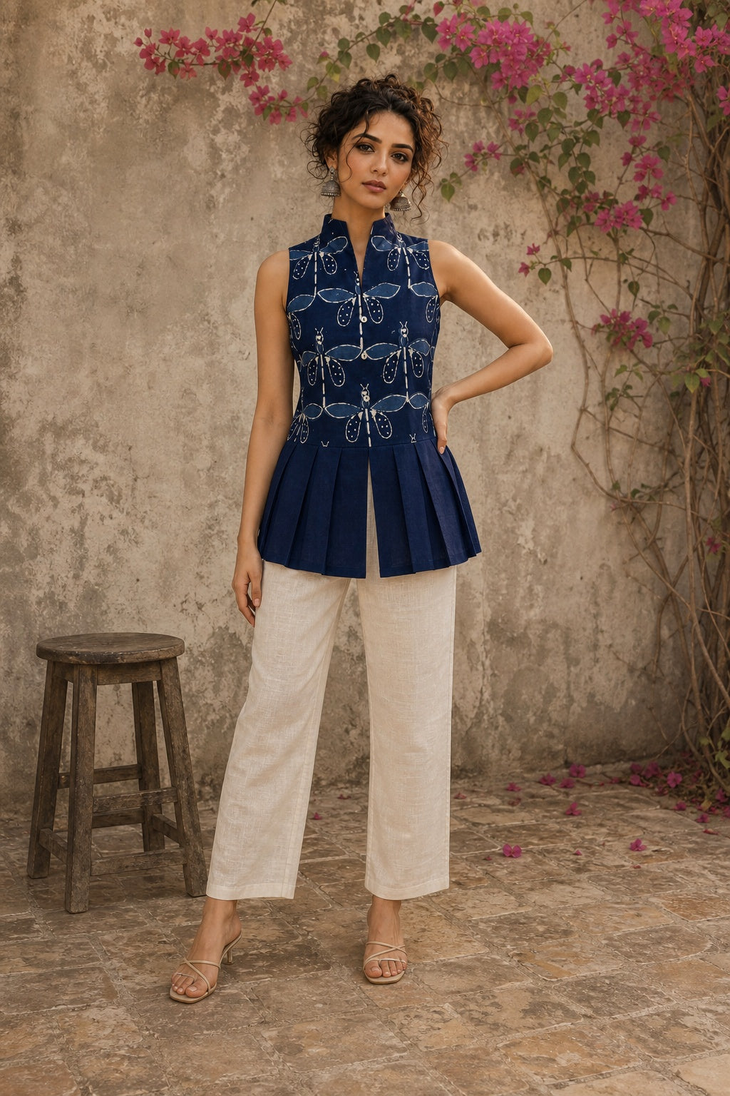 Contemporary indigo top with delicate dragonfly motifs, high folded collar, and graceful pleated hemline.