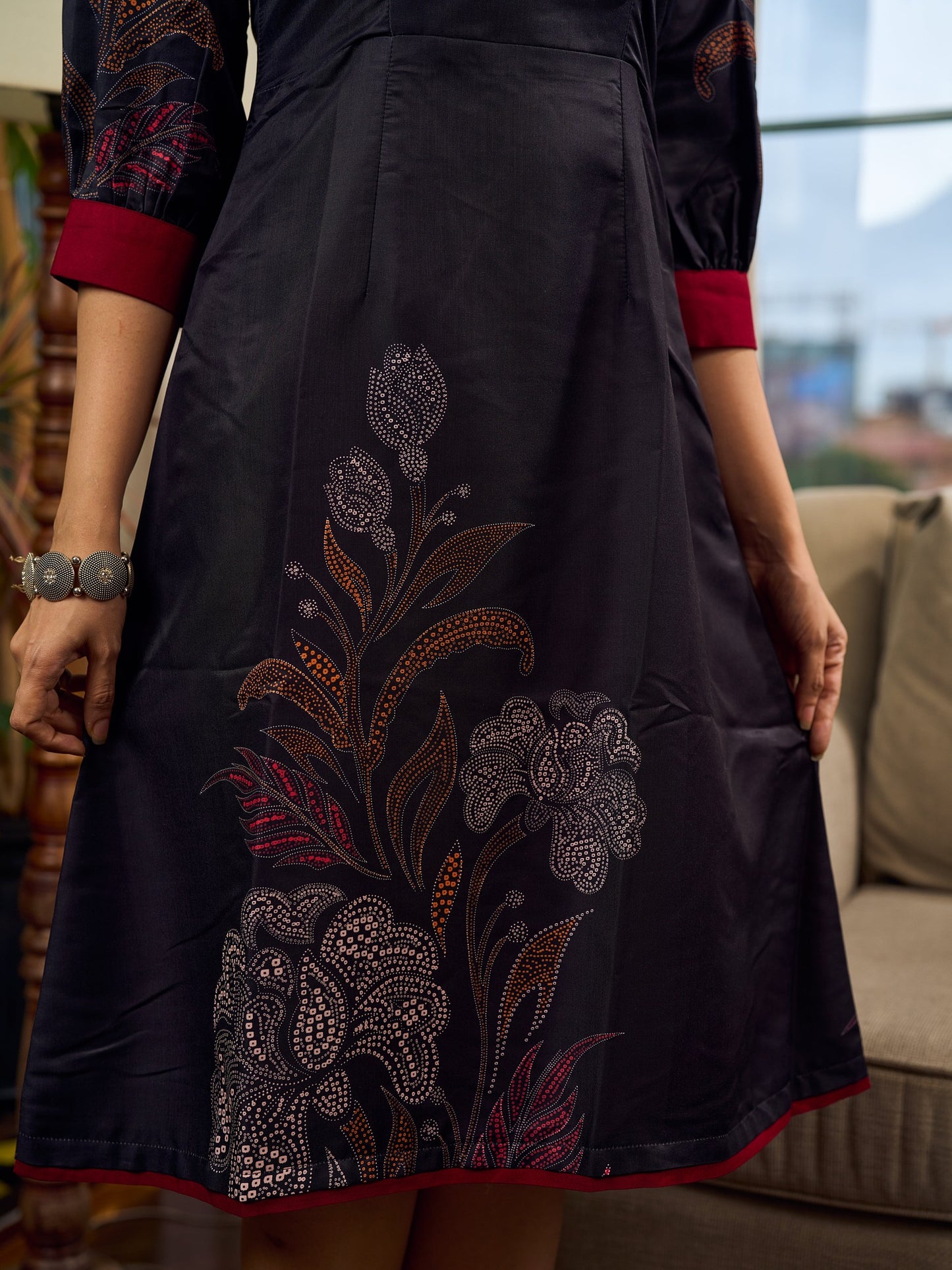 Elegant black Kalamkari-inspired dress with deep maroon accents and graceful floral motifs.