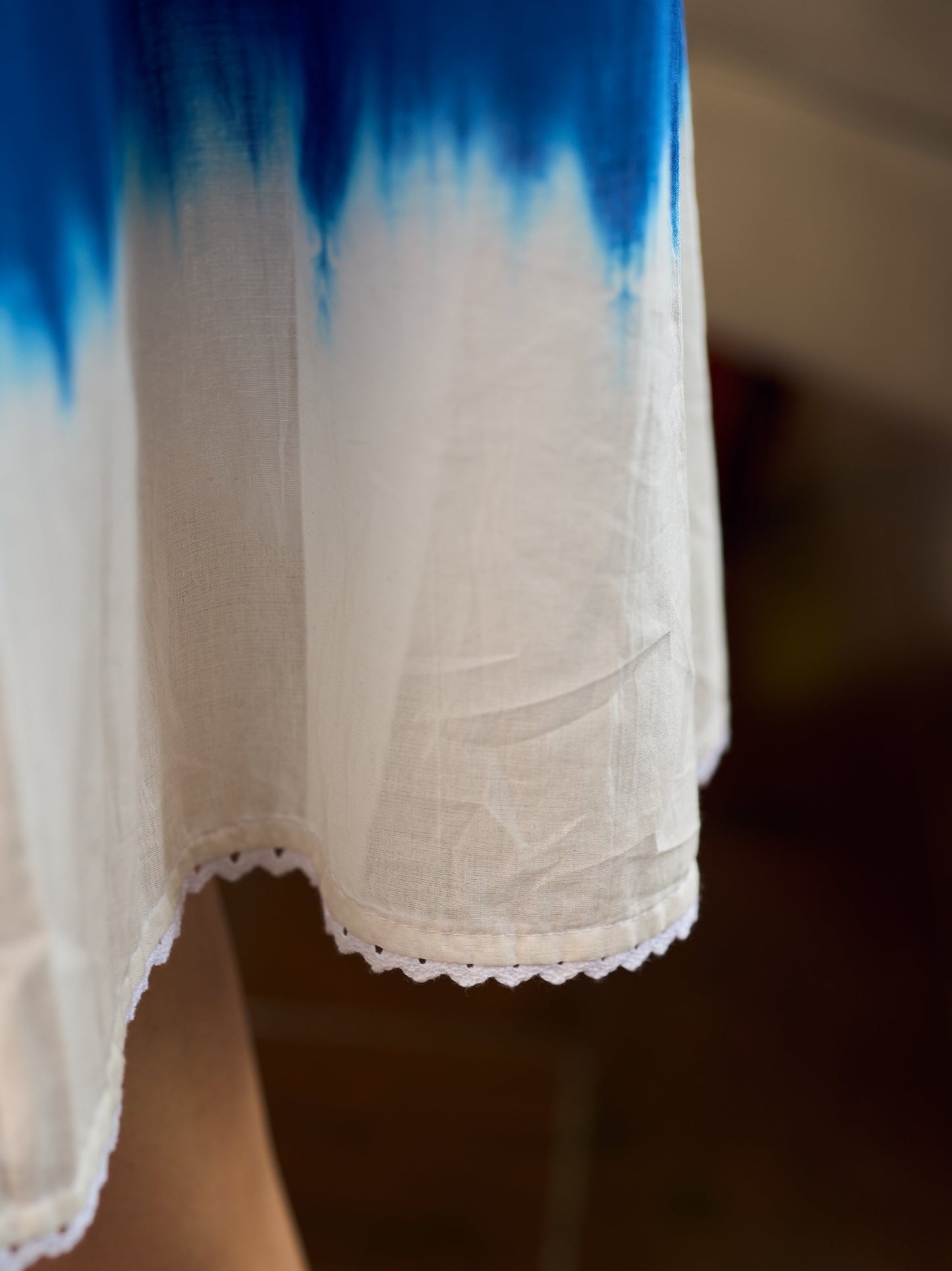 Refreshing cobalt blue shibori tie-dye dress with ivory accents and delicate lace-trimmed neckline.