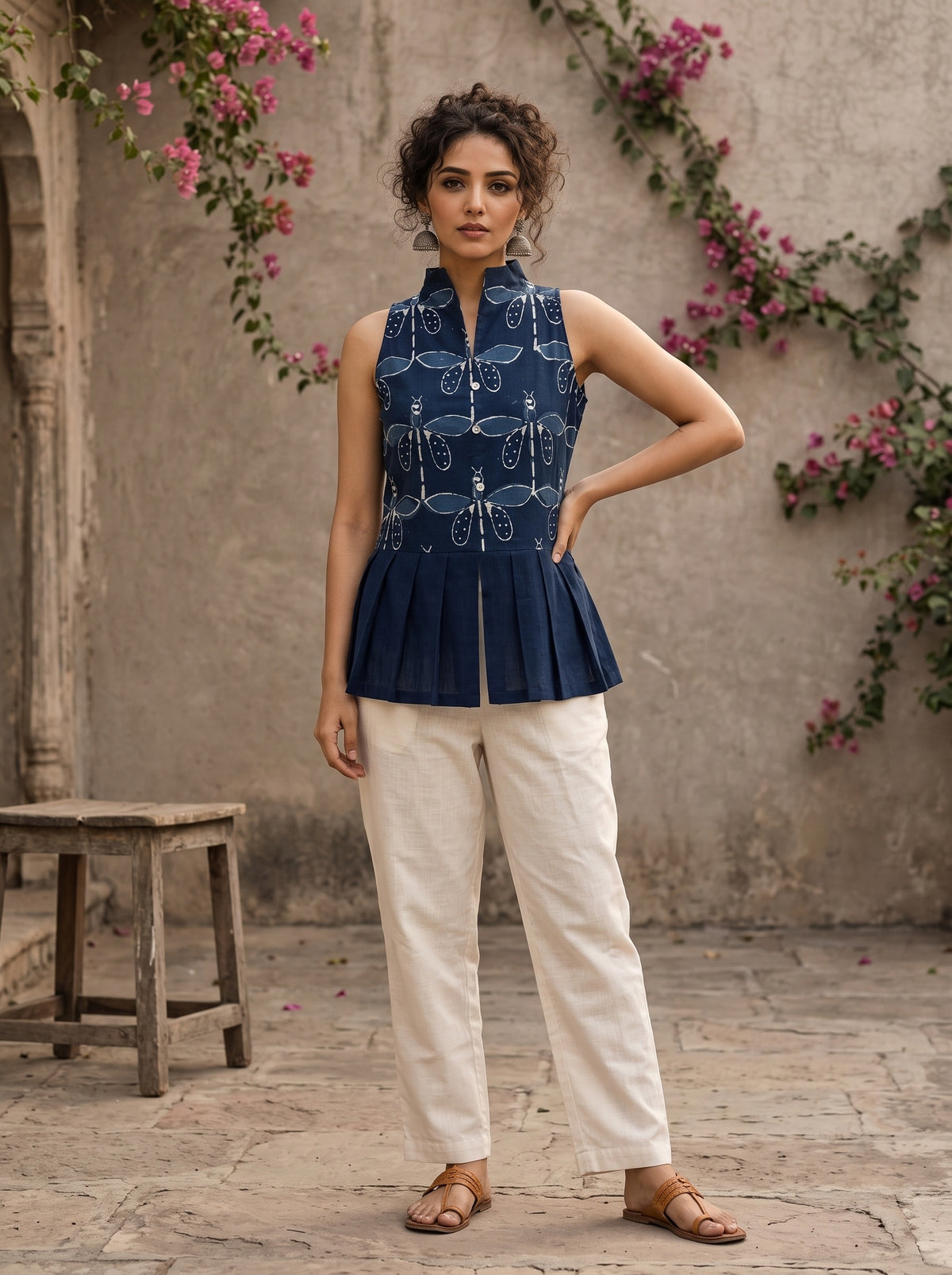 Contemporary indigo top with delicate dragonfly motifs, high folded collar, and graceful pleated hemline.