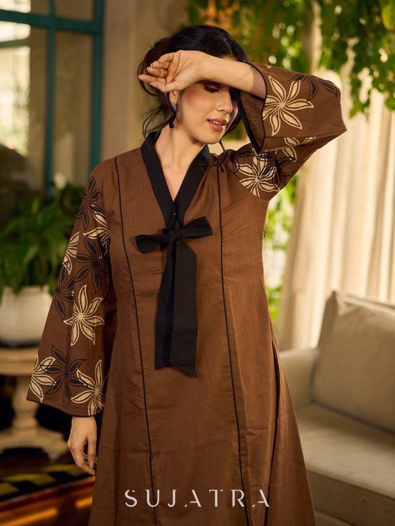 Brown block print dress with floral block printed flared sleeves, black tie-up neckline, and contrast black accents for an effortless, elegant everyday look.