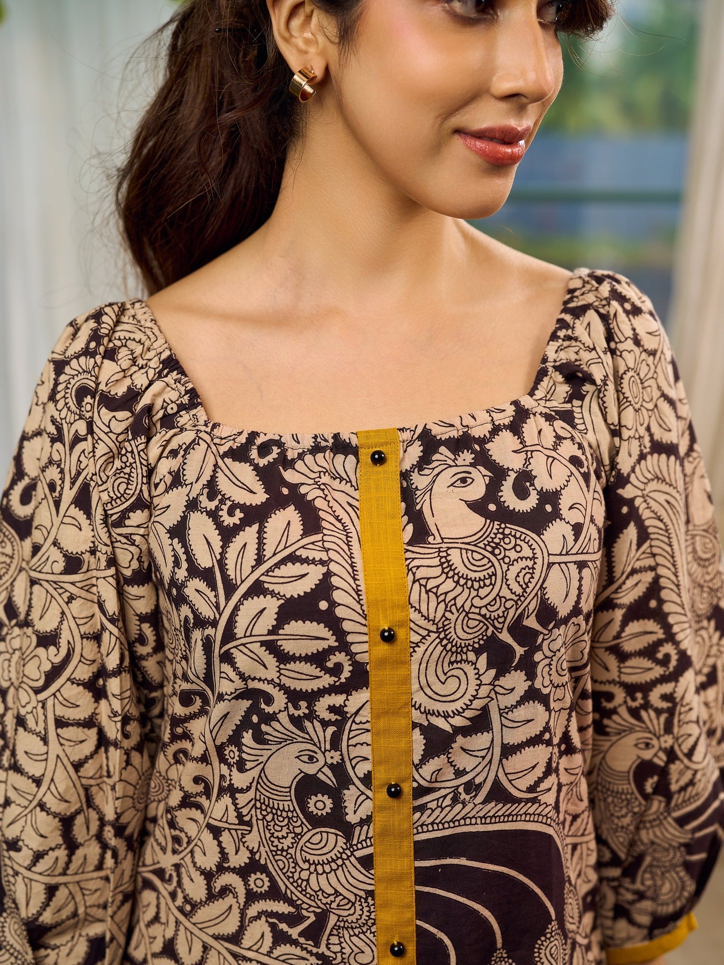 Heritage Kalamkari dress with elegant mustard accents and black pearl embellishments.