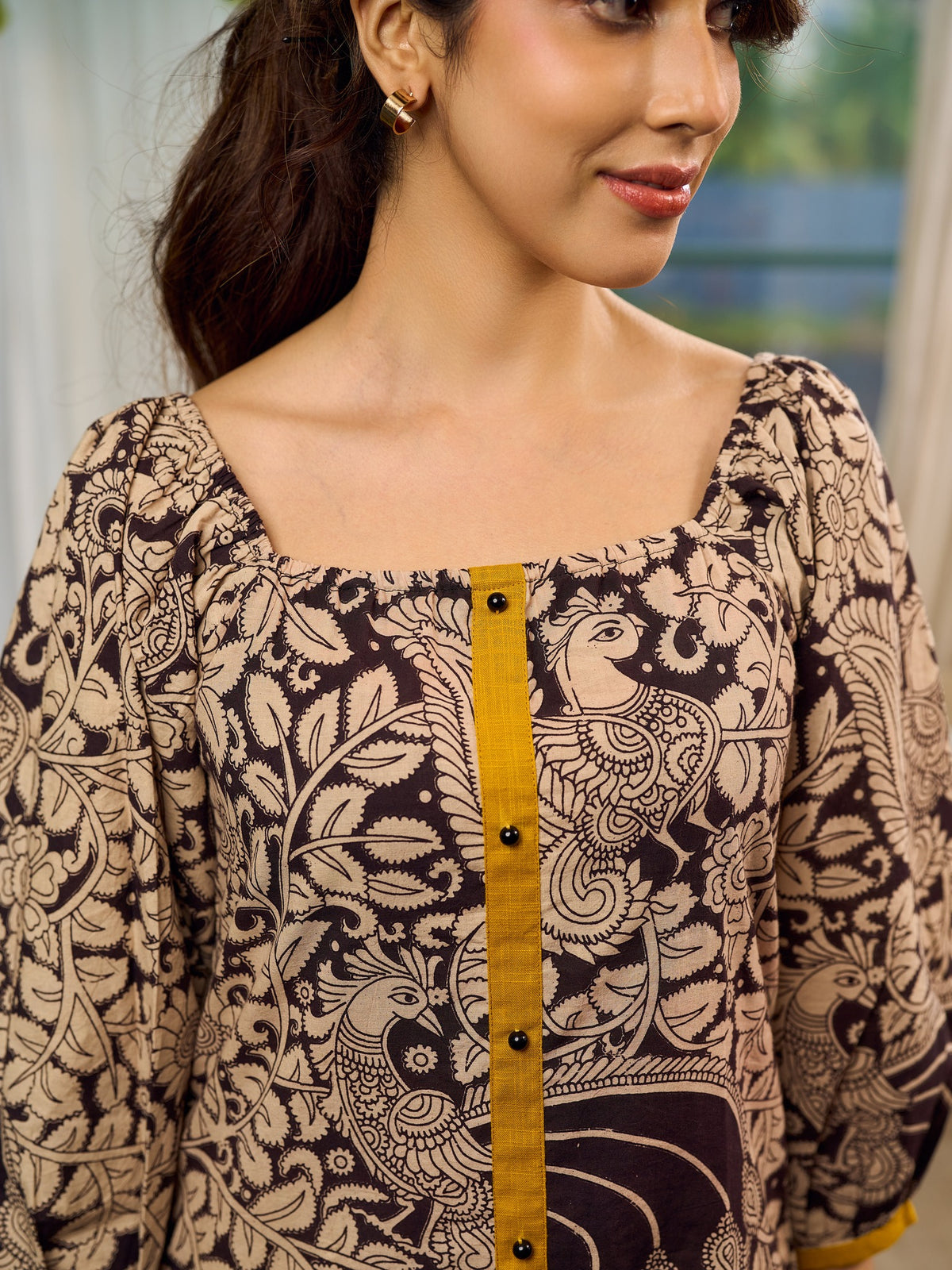 Heritage Kalamkari dress with elegant mustard accents and black pearl embellishments.