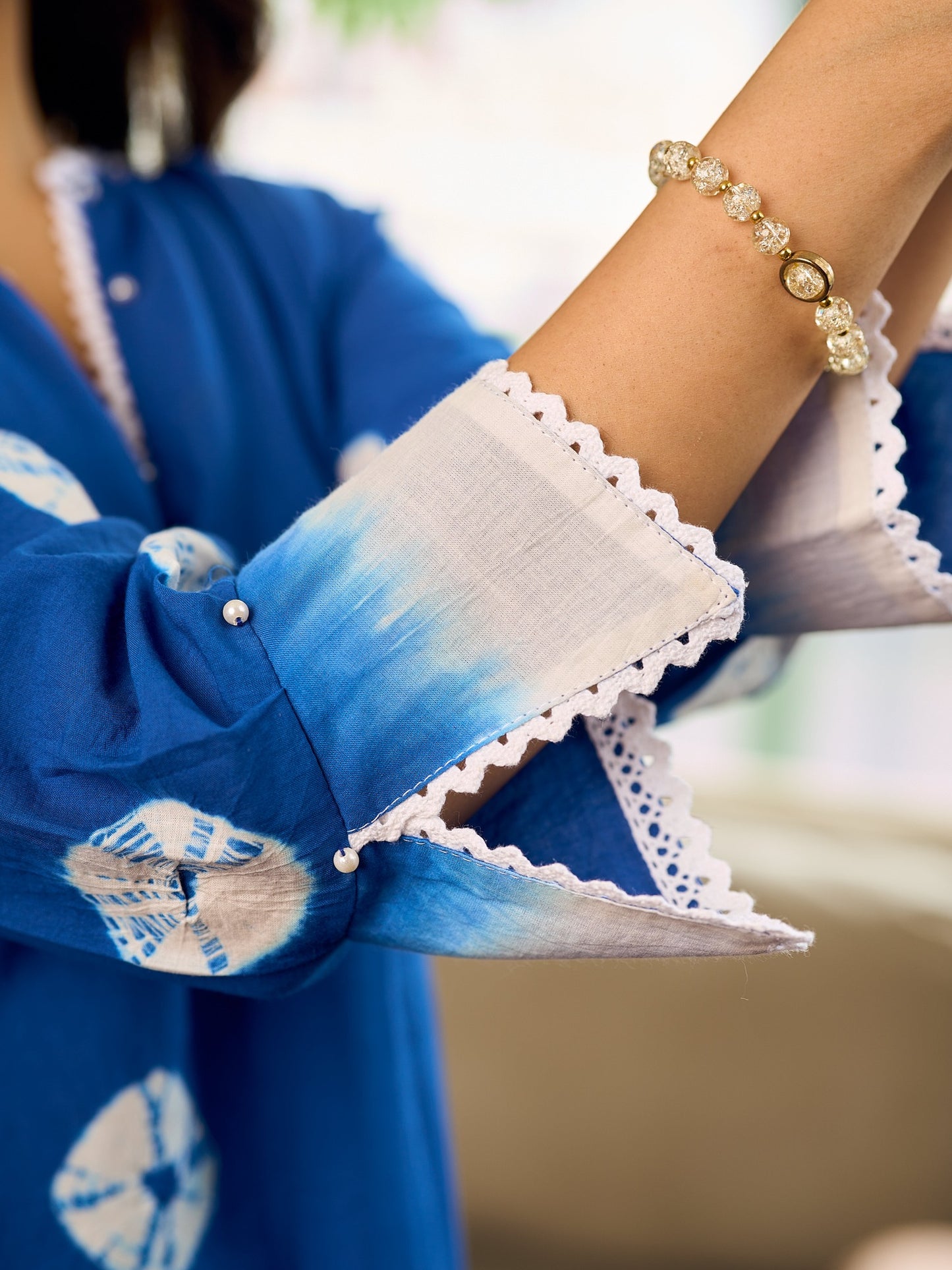 Refreshing cobalt blue shibori tie-dye dress with ivory accents and delicate lace-trimmed neckline.