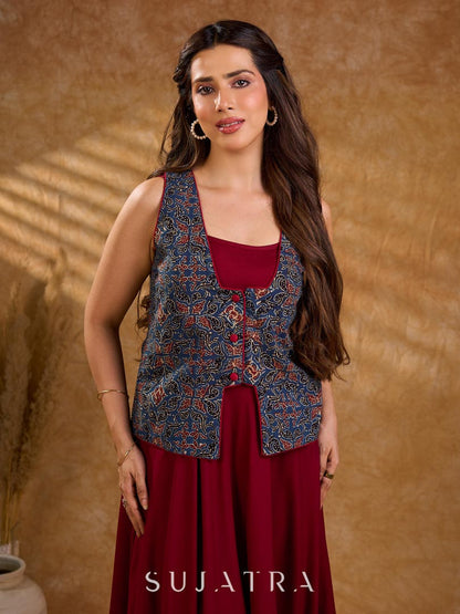 Handcrafted Ajrakh sleeveless jacket featuring front flaps, maroon detailing, breathable fabric, and a contemporary ethnic fusion appeal.