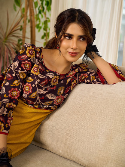 Mustard Kalamkari dress with an asymmetrical yoke and puffed sleeves.