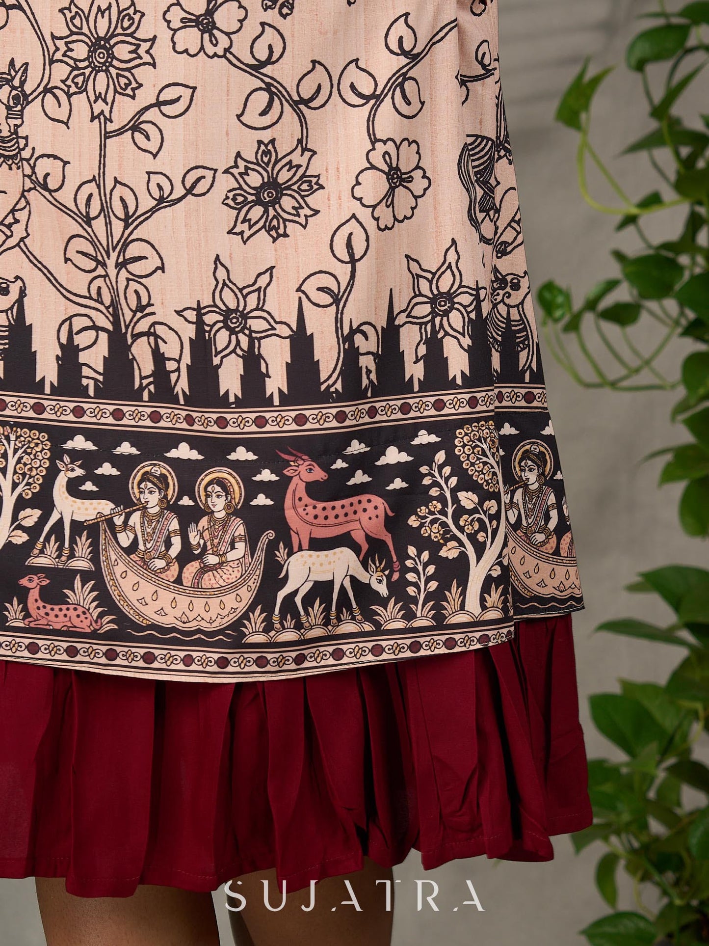 Beige traditional printed dress with rich maroon accents.