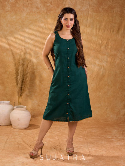 Rich bottle green cotton dress in a straight silhouette, detailed with mustard Ikat buttons and accents, creating a neat, balanced look with a polished, easygoing appeal.