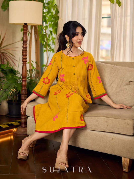 Mustard block printed pintuck dress with hand block red and pink vine floral motifs, accented with red and olive details for a rich, elegant look.