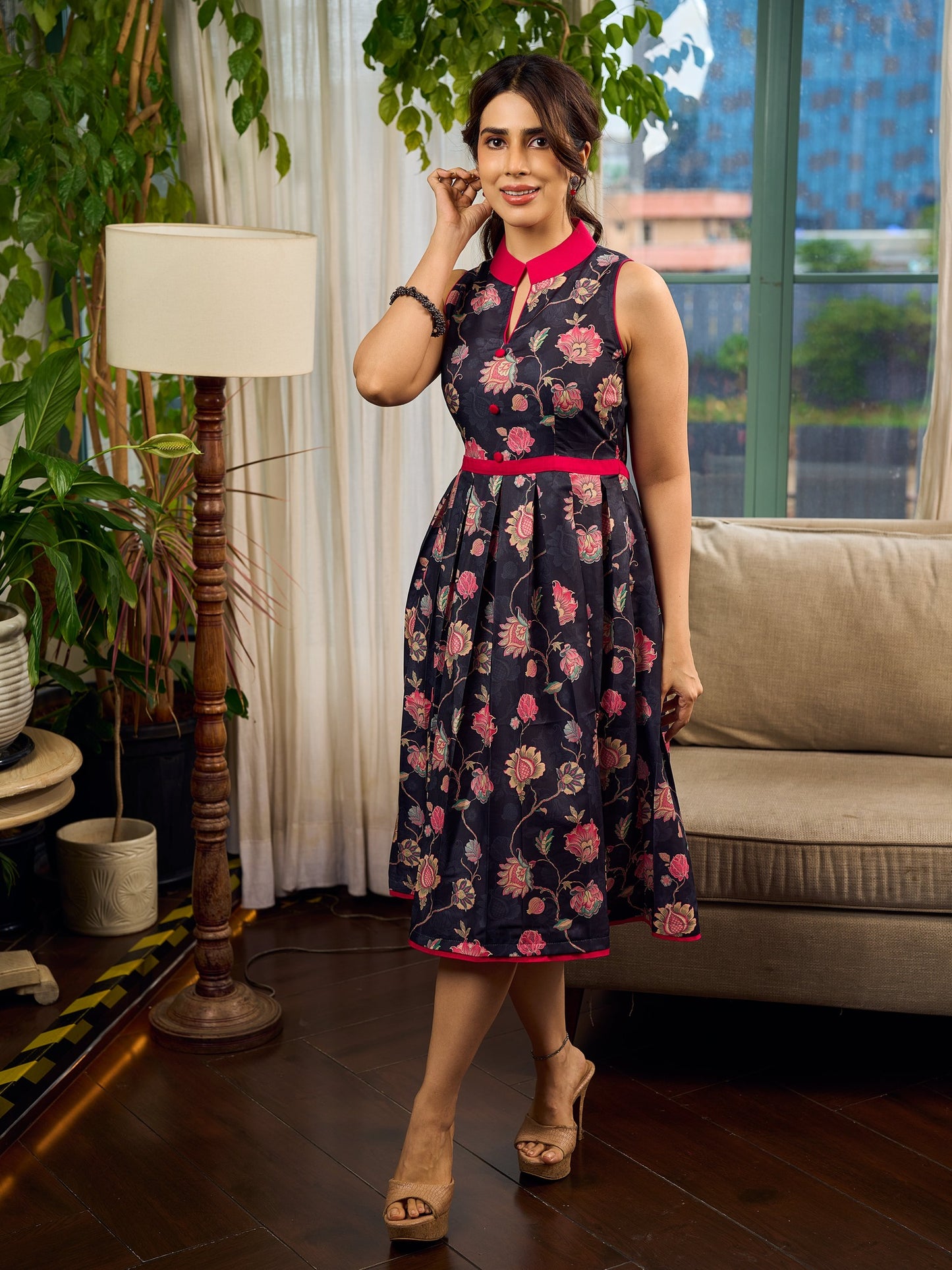 Elegant black Kalamkari dress featuring blooming florals and contrasting pink detailing for refined charm.