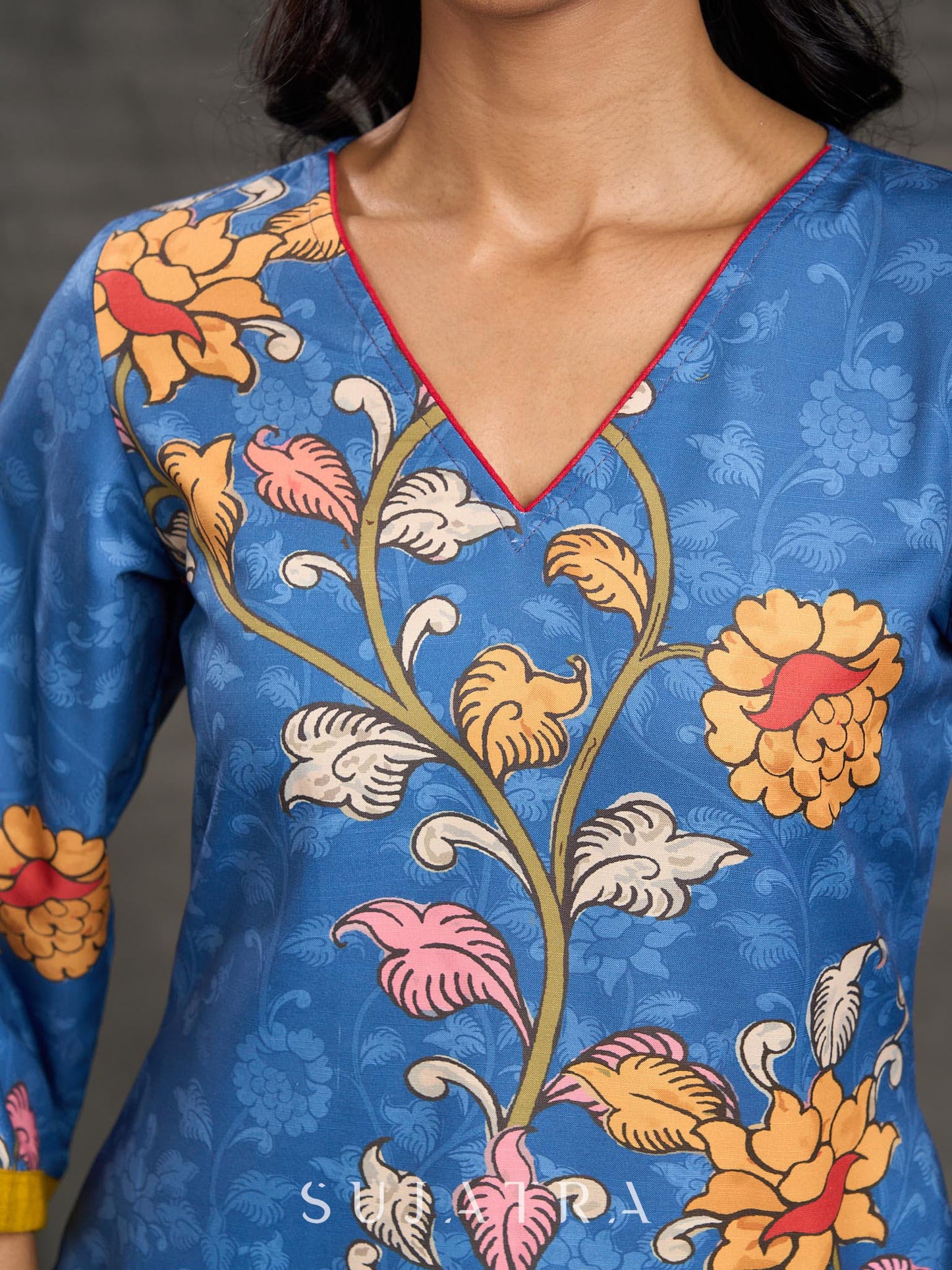 Indigo Kalamkari printed dress with vibrant red and mustard accents.