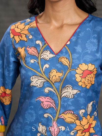 Indigo Kalamkari printed dress with vibrant red and mustard accents.