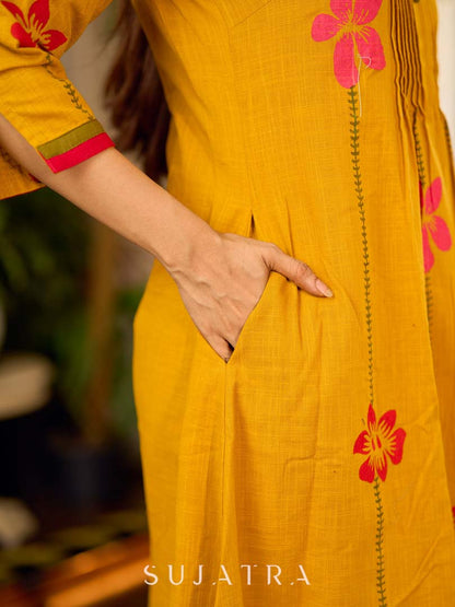 Mustard block printed pintuck dress with hand block red and pink vine floral motifs, accented with red and olive details for a rich, elegant look.