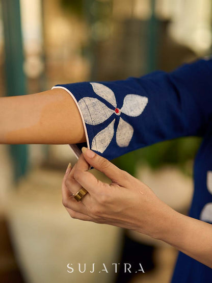 Navy blue apple-cut shirt dress with white floral hand block motifs, conceptually placed and finished with clean white edging and red accents for a refined, contemporary look.