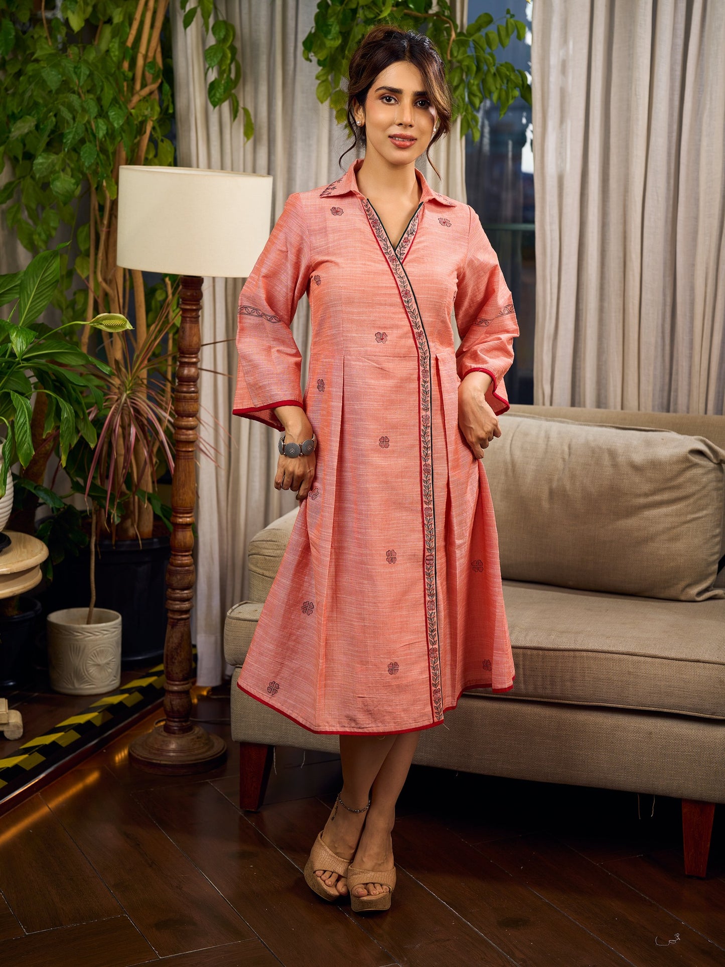Peach dress featuring delicate Madhubani painting and graceful flared sleeves.