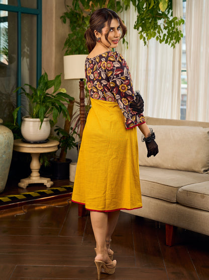 Mustard Kalamkari dress with an asymmetrical yoke and puffed sleeves.