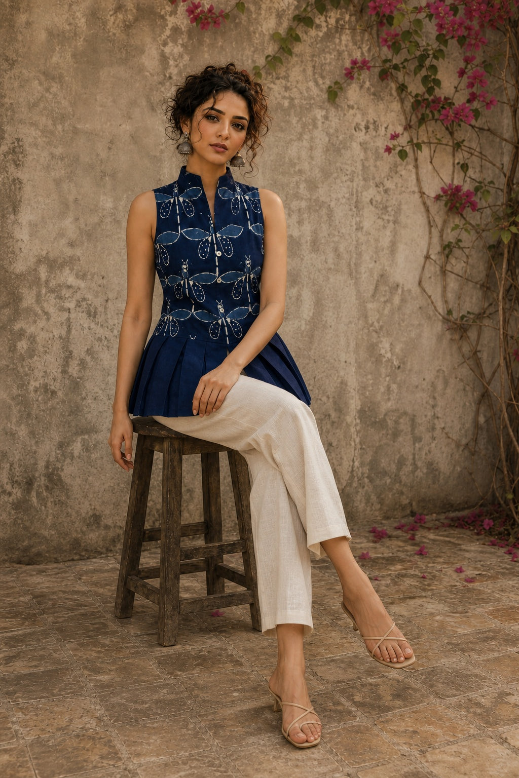 Contemporary indigo top with delicate dragonfly motifs, high folded collar, and graceful pleated hemline.