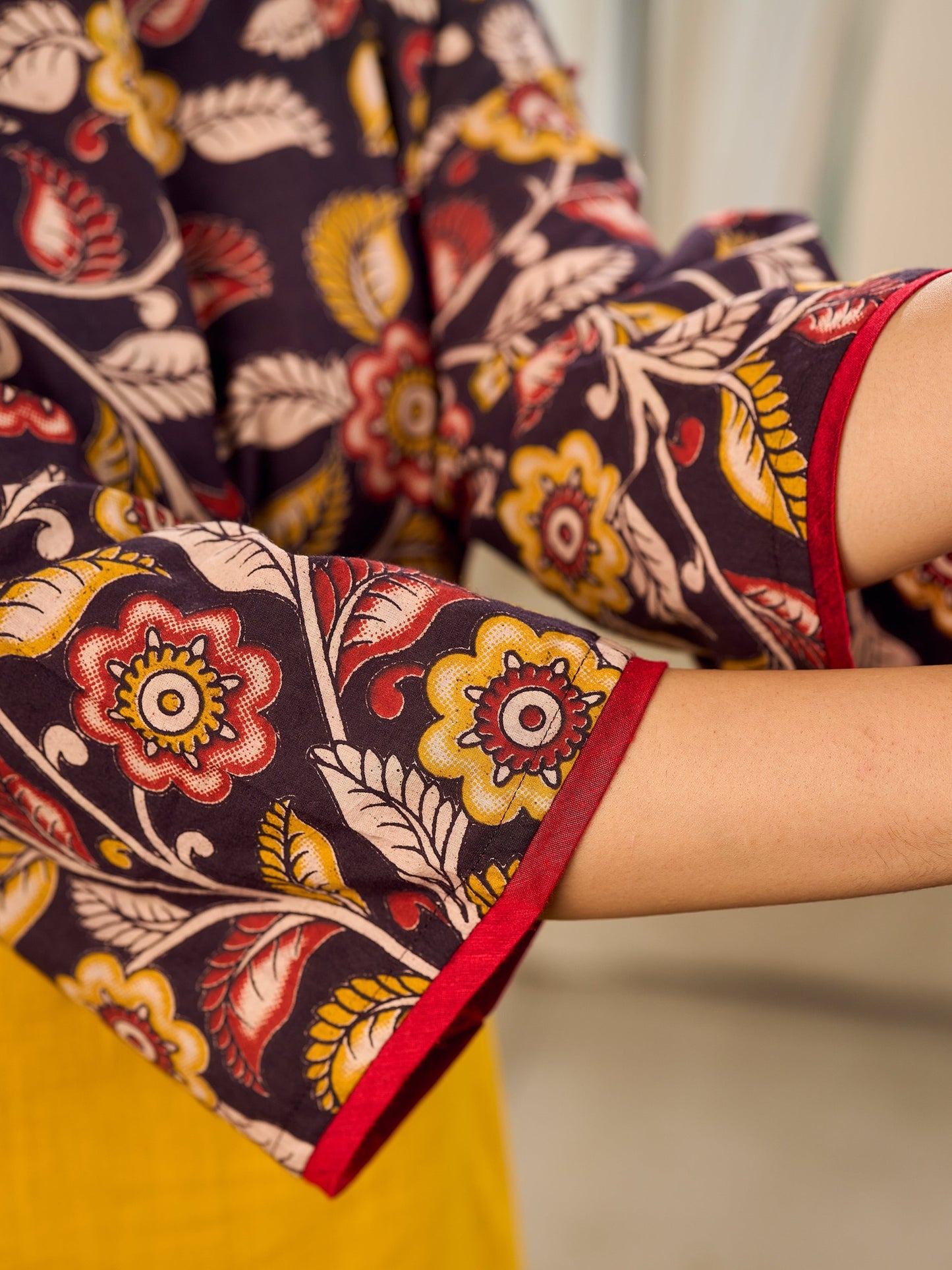 Mustard Kalamkari dress with an asymmetrical yoke and puffed sleeves.