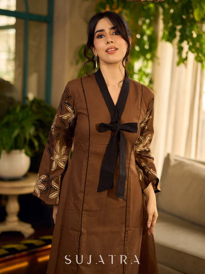 Brown block print dress with floral block printed flared sleeves, black tie-up neckline, and contrast black accents for an effortless, elegant everyday look.