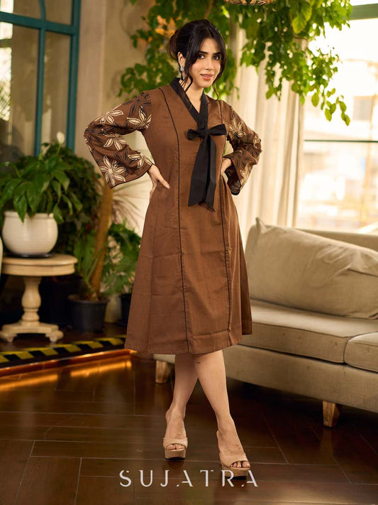 Brown block print dress with floral block printed flared sleeves, black tie-up neckline, and contrast black accents for an effortless, elegant everyday look.