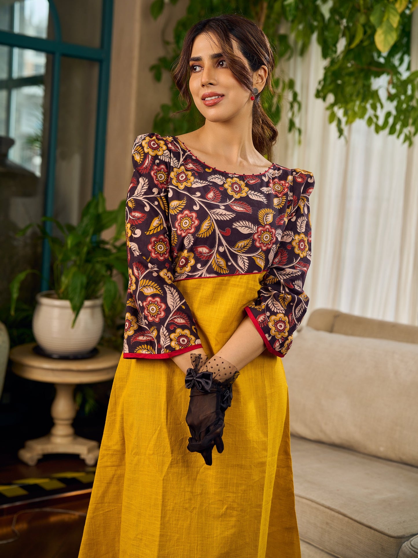 Mustard Kalamkari dress with an asymmetrical yoke and puffed sleeves.