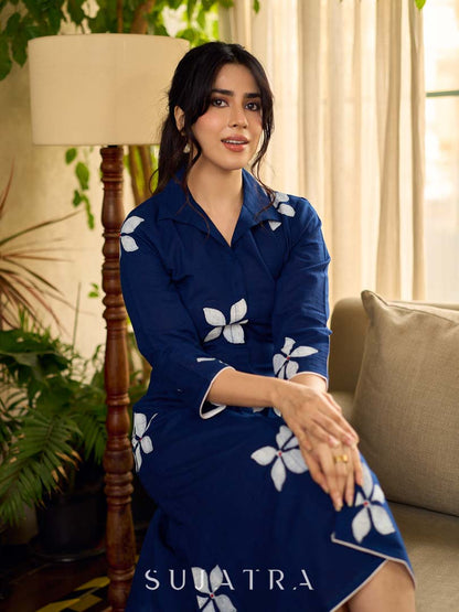 Navy blue apple-cut shirt dress with white floral hand block motifs, conceptually placed and finished with clean white edging and red accents for a refined, contemporary look.