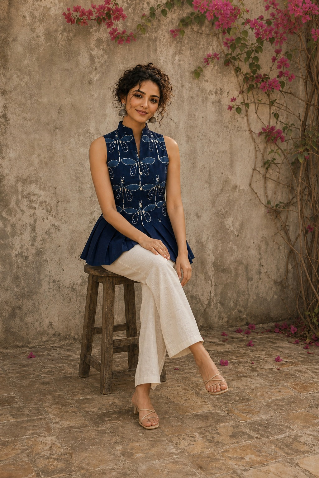 Contemporary indigo top with delicate dragonfly motifs, high folded collar, and graceful pleated hemline.