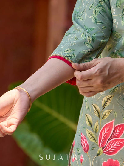 Soft green printed kurta with vibrant floral motifs, highlighted with hand embroidery and bright magenta accents.