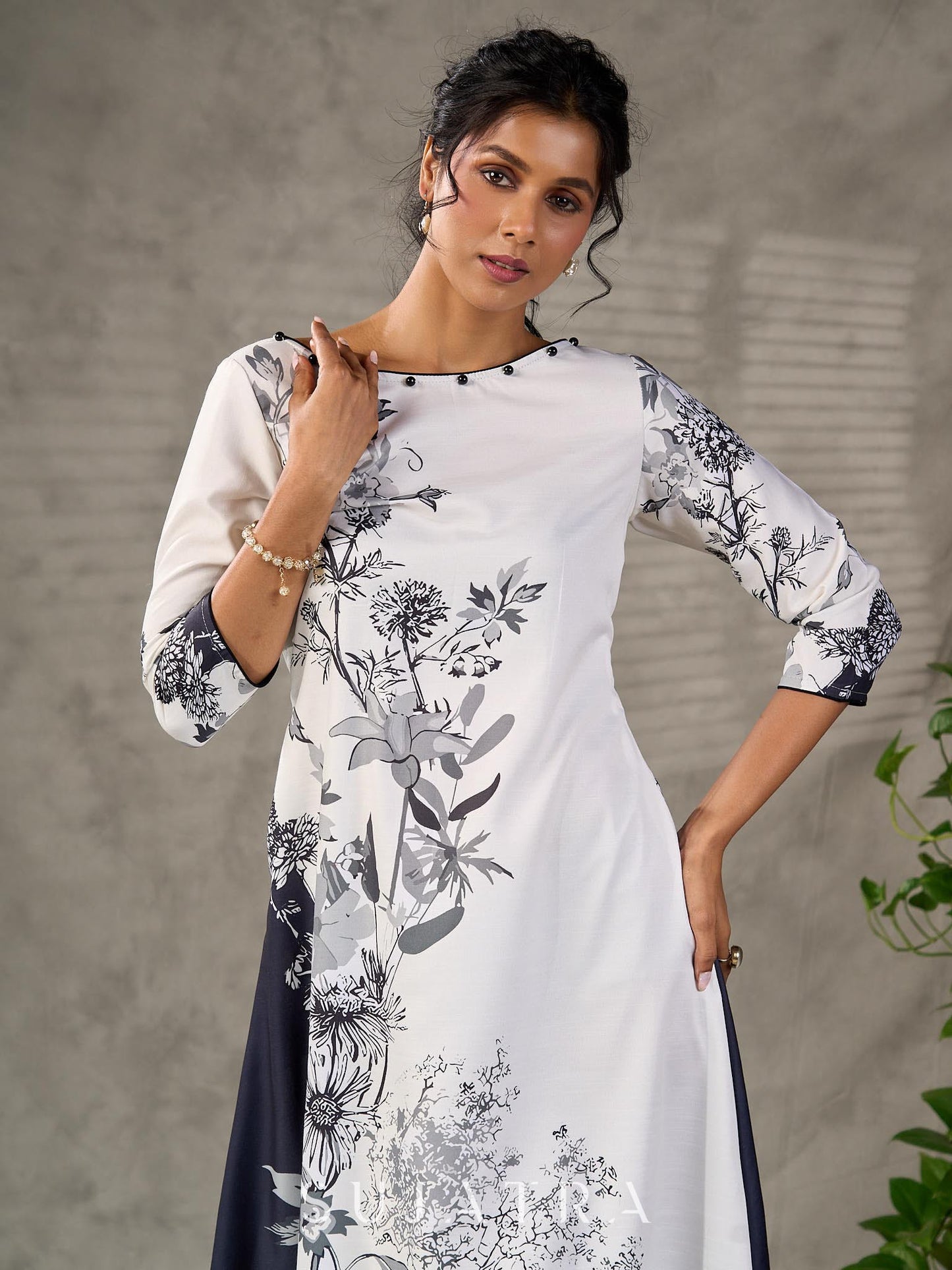 White and black floral dress with pearl embellishments and black accents.