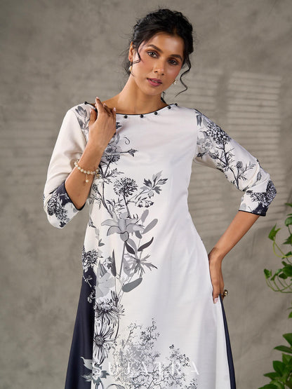White and black floral dress with pearl embellishments and black accents.