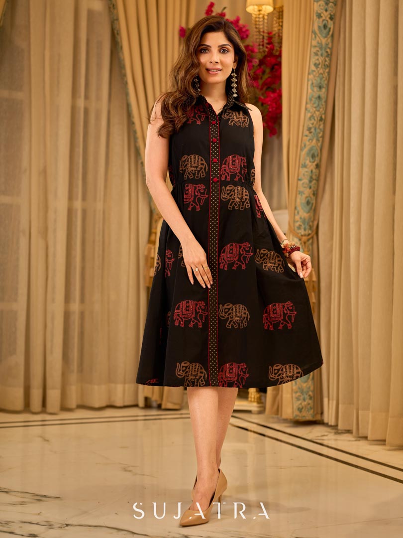 Statement black sleeveless shirt dress showcasing elephant-inspired prints and polka dots, highlighted with maroon accents.