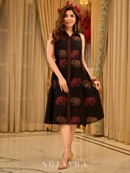 Statement black sleeveless shirt dress showcasing elephant-inspired prints and polka dots, highlighted with maroon accents.