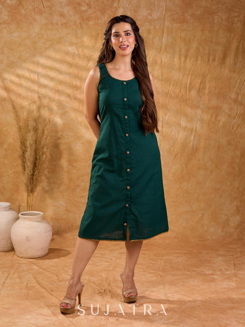 Rich bottle green cotton dress in a straight silhouette, detailed with mustard Ikat buttons and accents, creating a neat, balanced look with a polished, easygoing appeal.