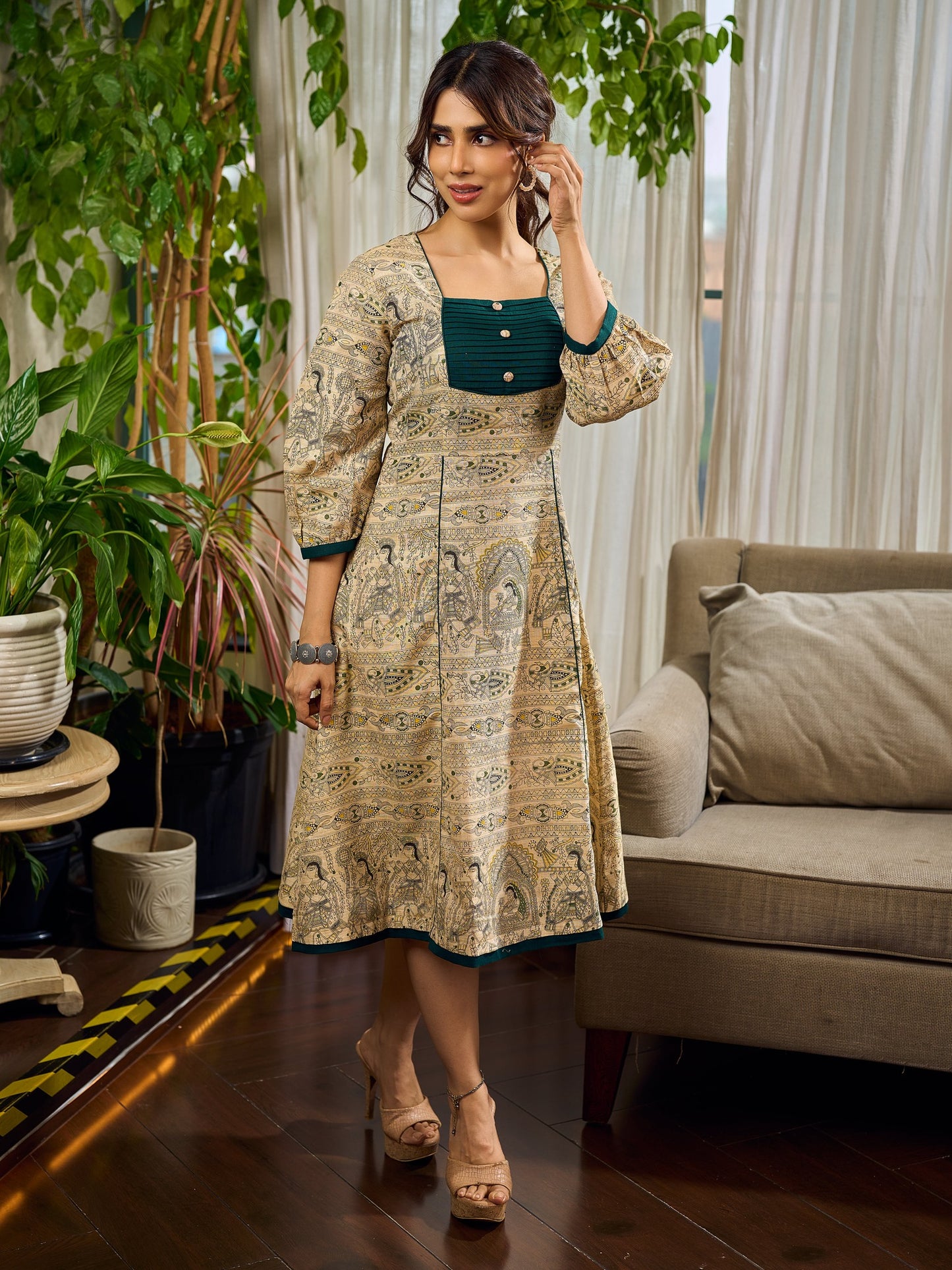 Artisanal beige Madhubani dress featuring intricate motifs, a contrasting green yoke, and refined accents.