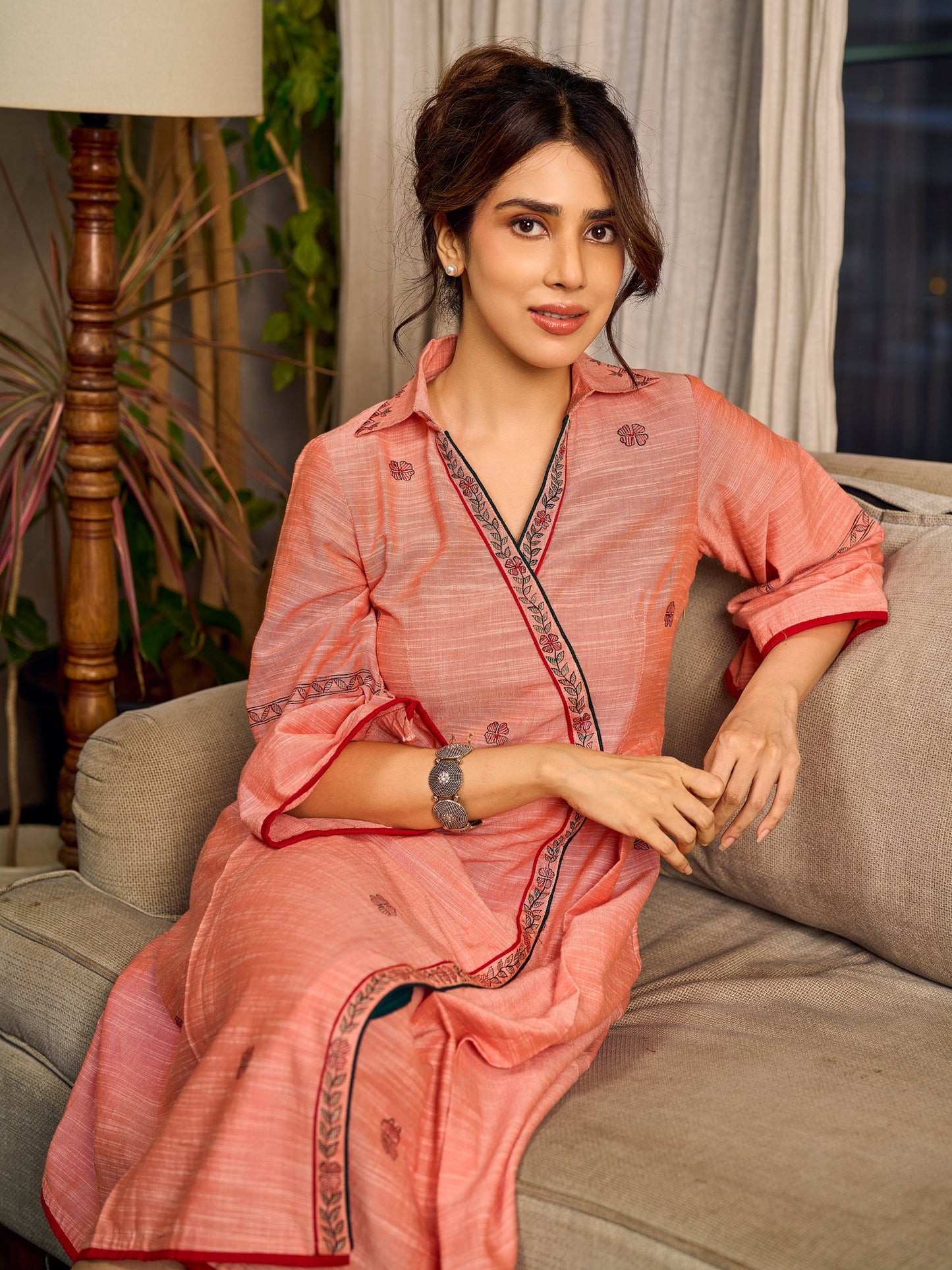 Peach dress featuring delicate Madhubani painting and graceful flared sleeves.