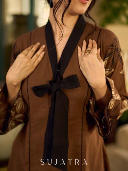 Brown block print dress with floral block printed flared sleeves, black tie-up neckline, and contrast black accents for an effortless, elegant everyday look.