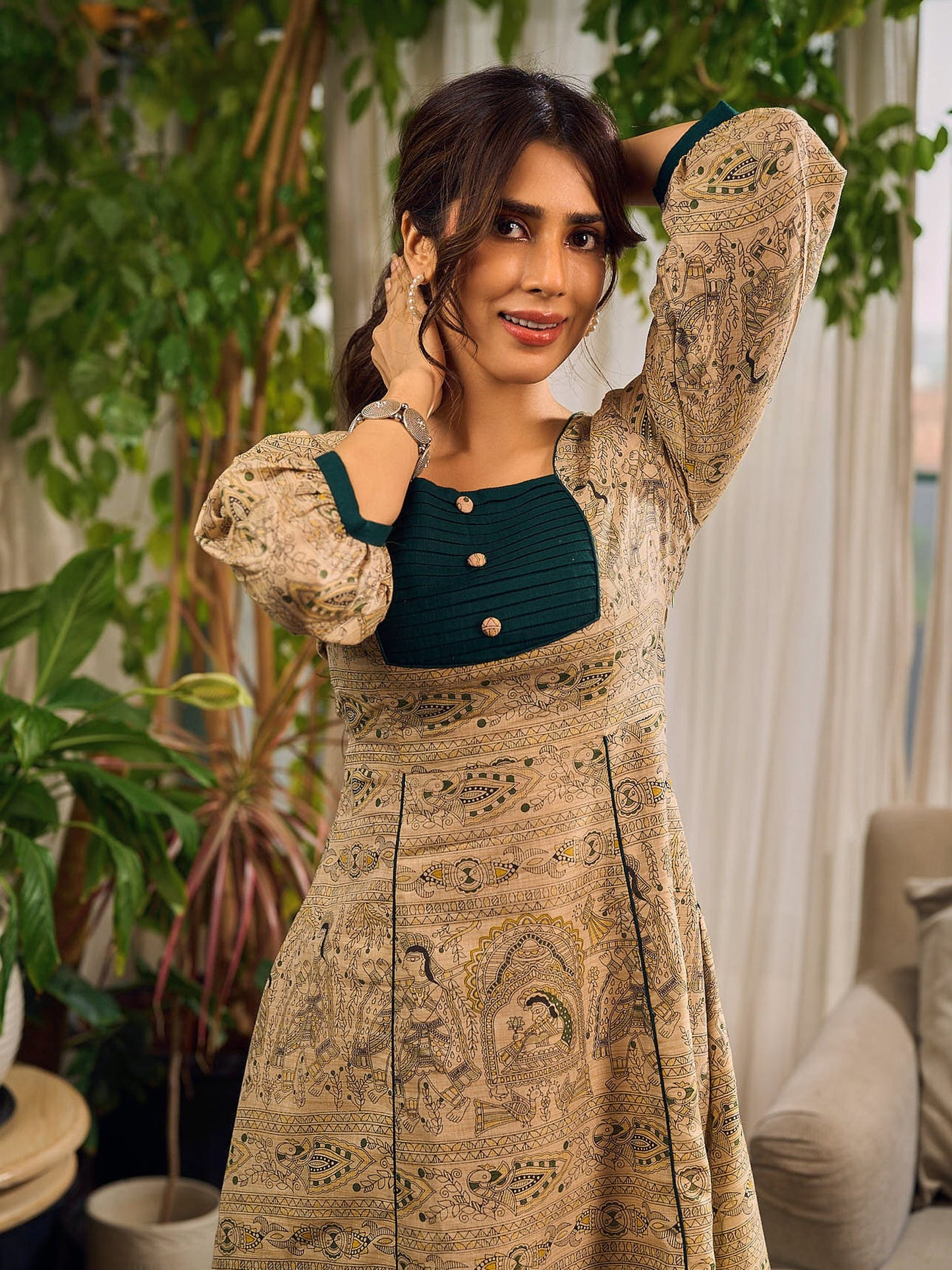 Artisanal beige Madhubani dress featuring intricate motifs, a contrasting green yoke, and refined accents.