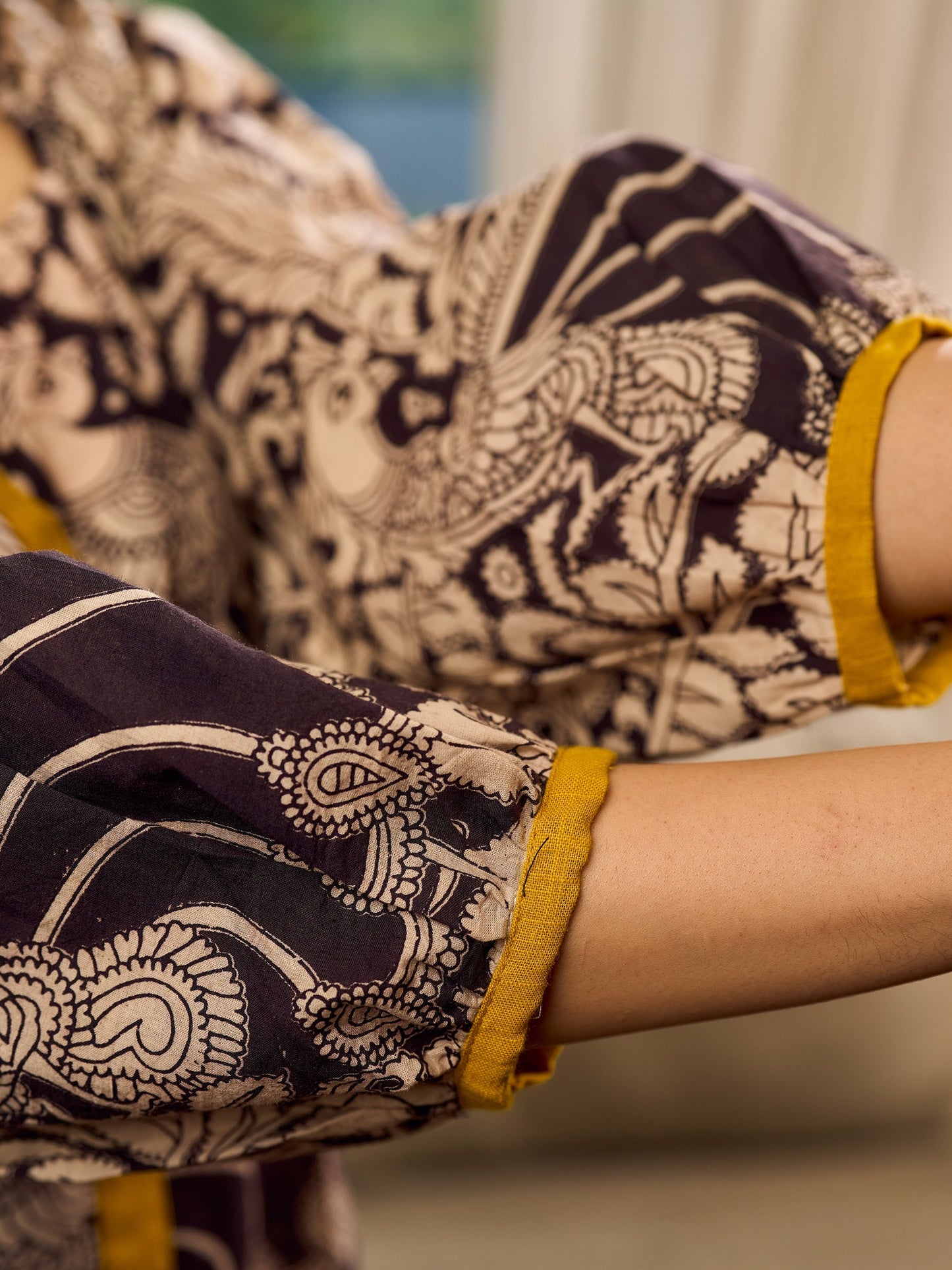 Heritage Kalamkari dress with elegant mustard accents and black pearl embellishments.