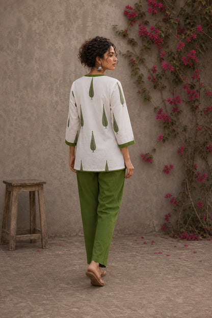 Pretty white Jaipur floral top featuring green leaf motifs, intricate pin-tuck neck, and feminine tie-lace details.