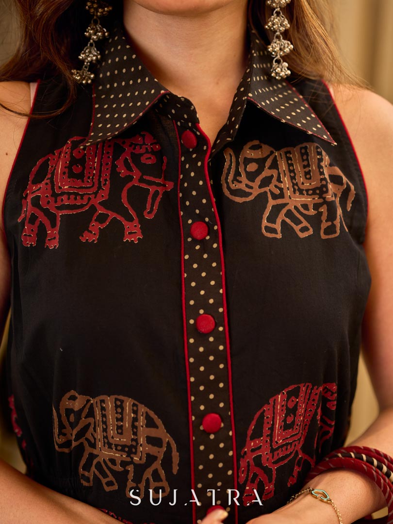 Statement black sleeveless shirt dress showcasing elephant-inspired prints and polka dots, highlighted with maroon accents.