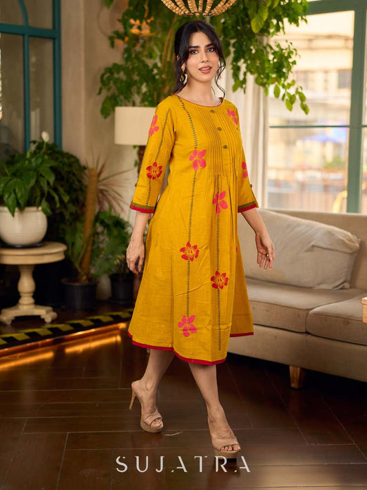 Mustard block printed pintuck dress with hand block red and pink vine floral motifs, accented with red and olive details for a rich, elegant look.